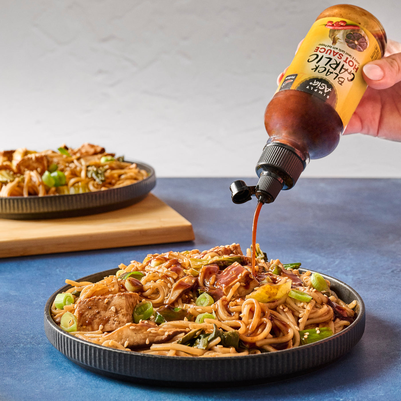 noodles on plate with sauce pouring