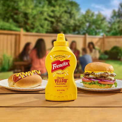 bottle of frenchs next to hot dog and cheeseburger