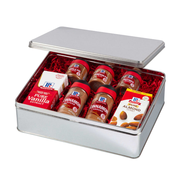 A silver tin filled with McCormick spices and almond extract.