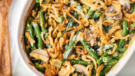 Green bean casserole with fried onions in a white dish.