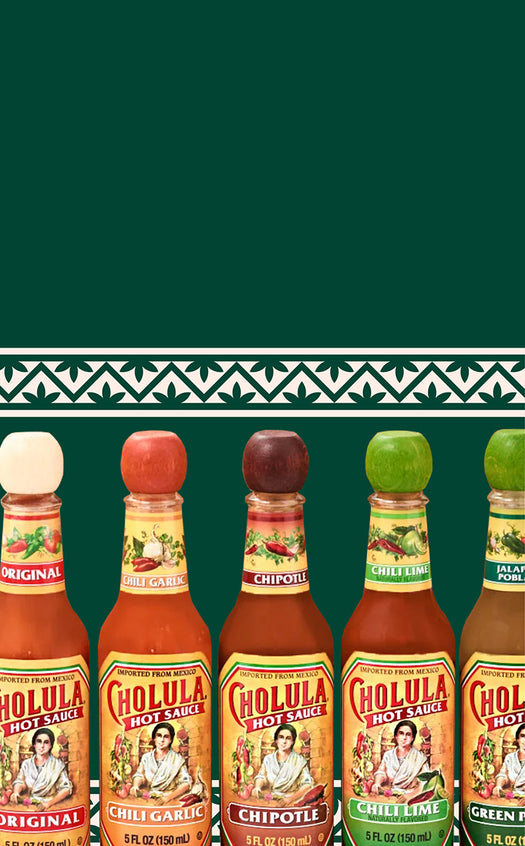 Row of Cholula hot sauce bottles on a green background