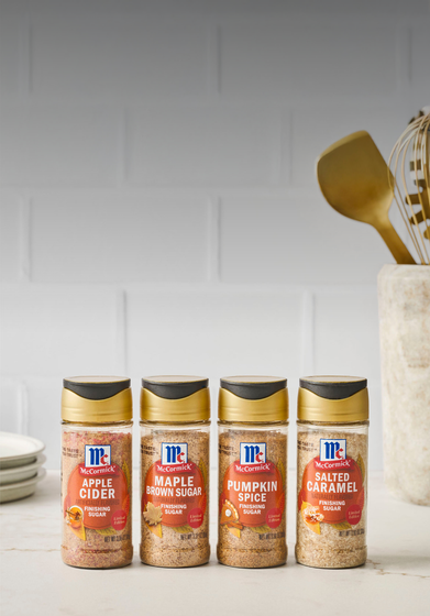 Four bottles of McCormick spice blends on a white surface with a white wall background.