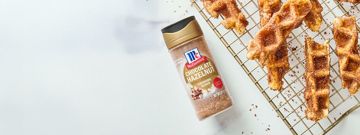 McCormick Chocolate Hazelnut Finishing Sugar next to waffle sticks coated in chocolate hazelnut sugar on a cooling rack