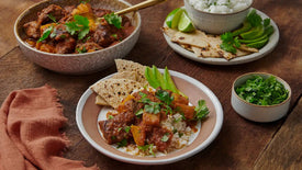 meat and potato dish with rice and tortillas, avocado, cilantro and lime