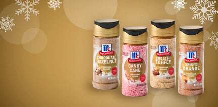 Four bottles of McCormick's Winter Sugars on a gold background with snowflake decorations.