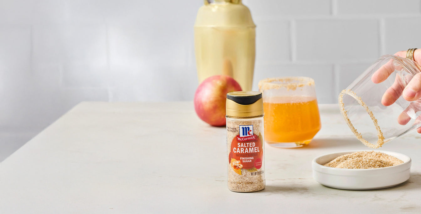 Glass rimmed with salted caramel sugar, McCormick Salted Caramel Finishing Sugar bottle, and drink