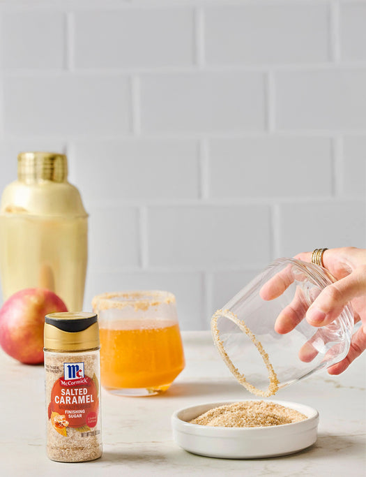 Glass rimmed with salted caramel sugar, McCormick Salted Caramel Finishing Sugar bottle, and drink