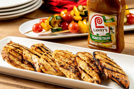 chicken marinated in lawry's signature italian marinade on a white rectangular plate with veggies on a skewer in the background