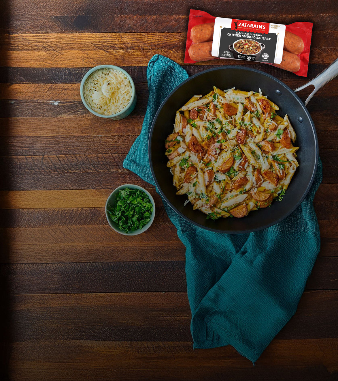 Fried pasta dish in a pan on a wooden table with Zatarain's seasoning packet.