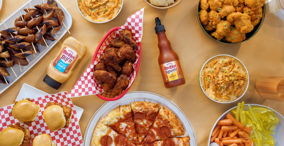 franks redhot dip'n and squeeze sauce on table among pizza and wings