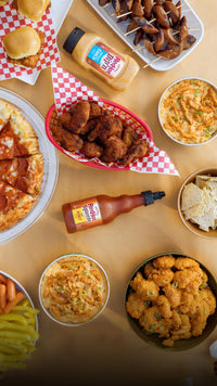 franks redhot dip'n and squeeze sauce on table among pizza and wings
