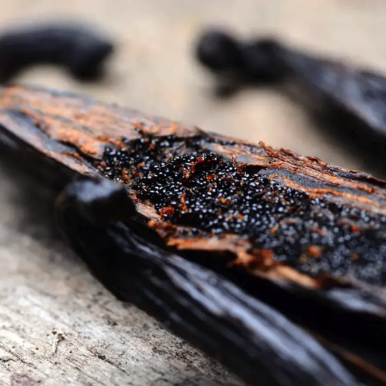 Close-up of a vanilla bean with a rough texture on a wooden surface