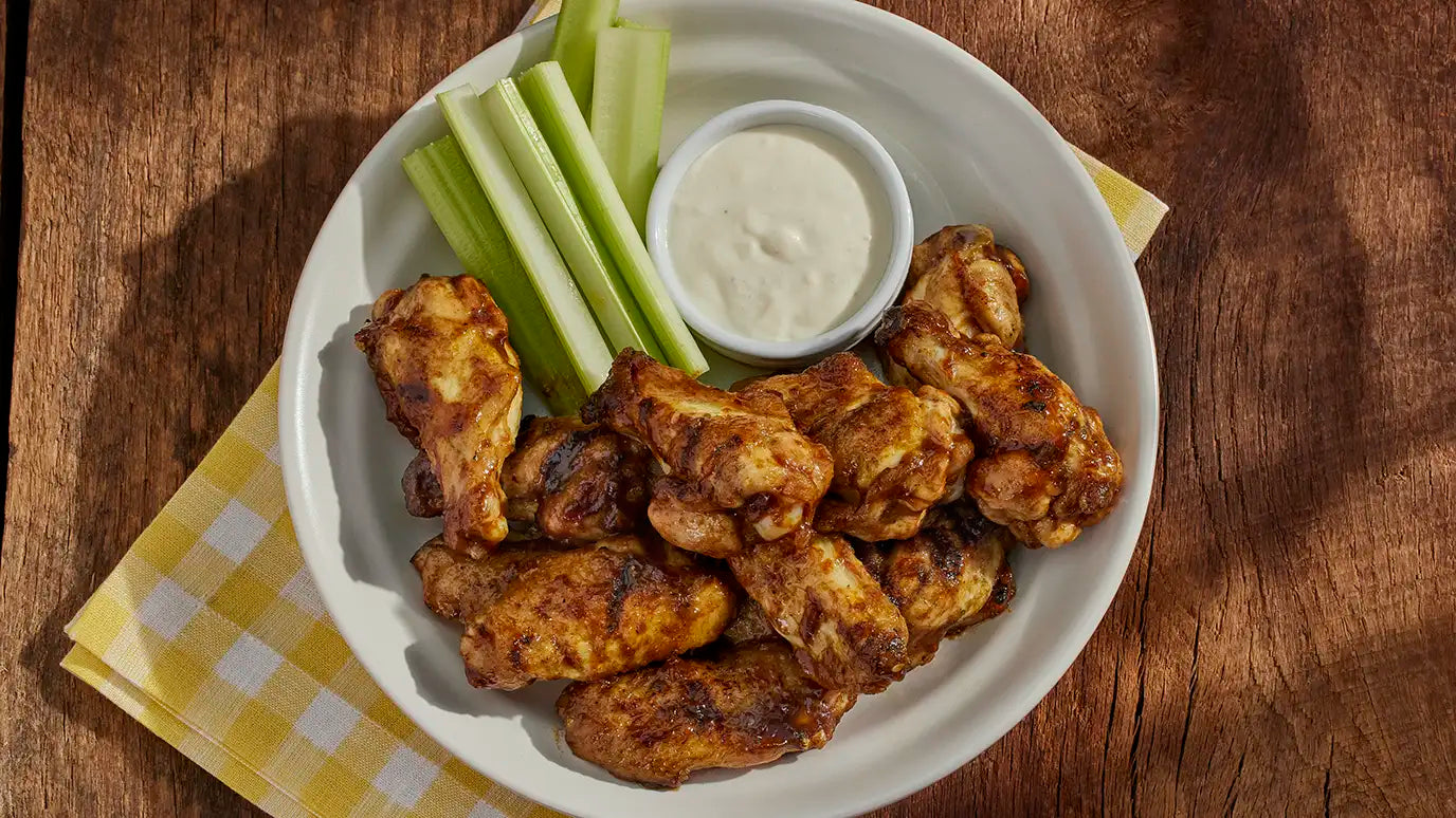 grilled wings on plate with celery and dipping sauce