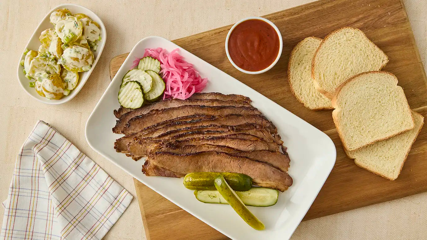 smoked brisket with fresh bread, pickles and potato salad
