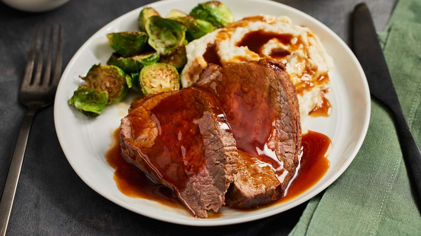 McCormick Perfect Brown Gravy over roast beef, mashed potatoes and brussels sprouts