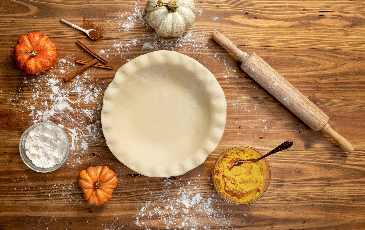 empty pie crust surrounded by pumpkins