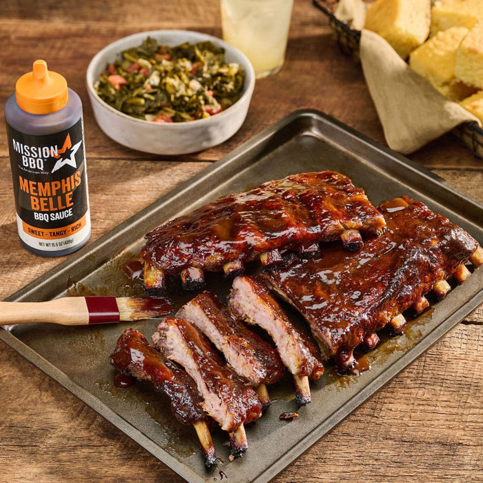 A tray of ribs glazed with Mission BBQ Memphis Belle BBQ Sauce is served with collard greens and cornbread.