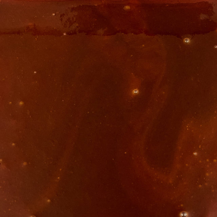 A vibrant close-up of the Mission Bbq Memphis Belle 15.5 Oz, showcasing its deep reddish-brown color and smooth, glossy texture with small bubbles