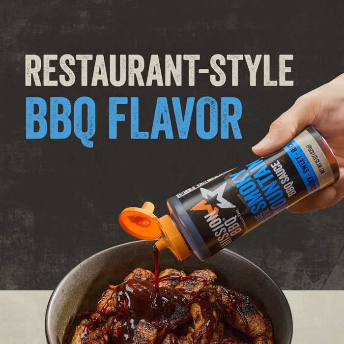 A hand pours Mission Bbq Blue Ridge Smoky Mountain 15 Oz BBQ sauce from its bottle onto grilled chicken pieces in a bowl, highlighting the restaurant-style BBQ flavor.