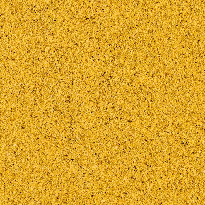 A close-up texture of yellow sand with small dark specks.