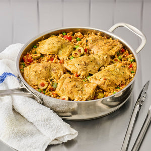 A stainless steel pan filled with chicken and rice dish, showcasing a flavorful and appetizing meal.