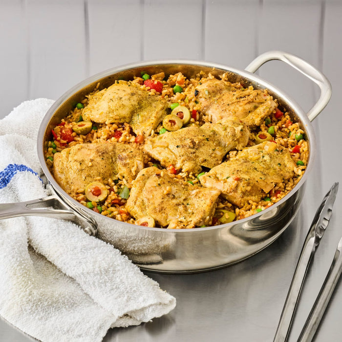 A stainless steel pan filled with chicken and rice dish, showcasing a flavorful and appetizing meal.