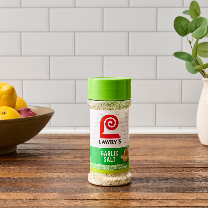 A bottle of Lawry's Garlic Salt on a wooden table.