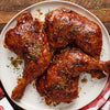 A plate of BBQ chicken pieces, likely featuring a brand like the one partially visible in the corner.