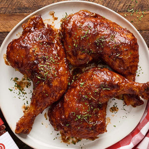 A plate of BBQ chicken pieces, likely featuring a brand like the one partially visible in the corner.