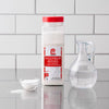 A container of Lawry'S Seasoning Salt &amp; Vinegar, 20 Oz is displayed on a countertop next to a small bowl of the seasoning and a glass cruet of vinegar.