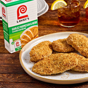 A box of Lawry's Garlic Herb Seasoning Blends sits next to a plate of breaded chicken cutlets, suggesting a delicious meal.