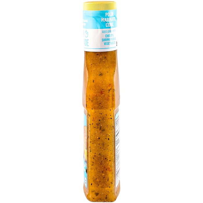A bottle of salad dressing with a yellow cap and visible herbs and spices.
