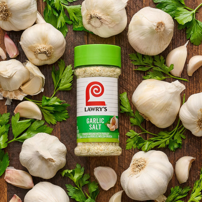 ["A jar of Lawry's Garlic Salt surrounded by garlic cloves and parsley."]