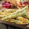 ['A close up of crispy fried green beans in a paper takeout container.']