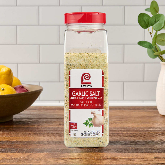 A container of McCormick Garlic Salt is displayed on a wooden countertop.