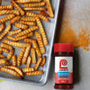 ["A tray of crispy french fries with a bottle of Lawry's Seasoned Salt."]