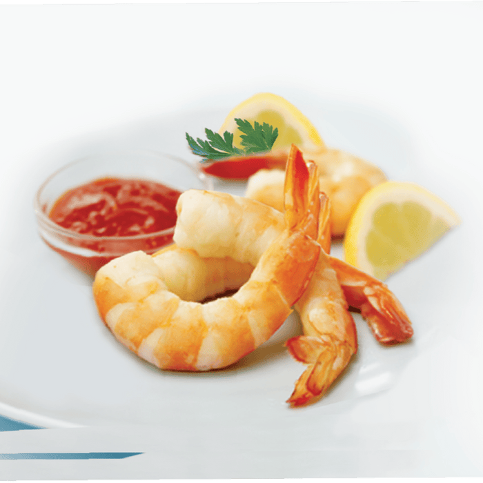 A plate of shrimp cocktail with cocktail sauce lemon wedges and parsley.