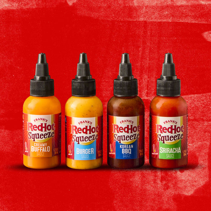 Four bottles of Franks RedHot Squeeze sauce in different flavors: Creamy Buffalo Burger Korean BBQ and Sriracha.