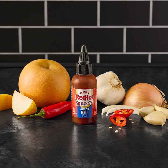 A bottle of Franks RedHot Squeeze Korean BBQ Sauce with a pear onion garlic and chili peppers.