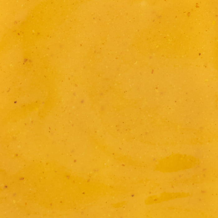 A close-up shot of a smooth vibrant yellow sauce with subtle texture ideal for culinary or food-related content.