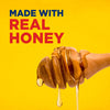 The image showcases a honey dipper dripping with real honey against a vibrant yellow background emphasizing the natural ingredient.