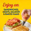 A hand squeezes French's Maple Mustard onto a sandwich with the text "Enjoy on Sandwiches, Meats, Salmon &amp; Baked Hams" on a yellow background.