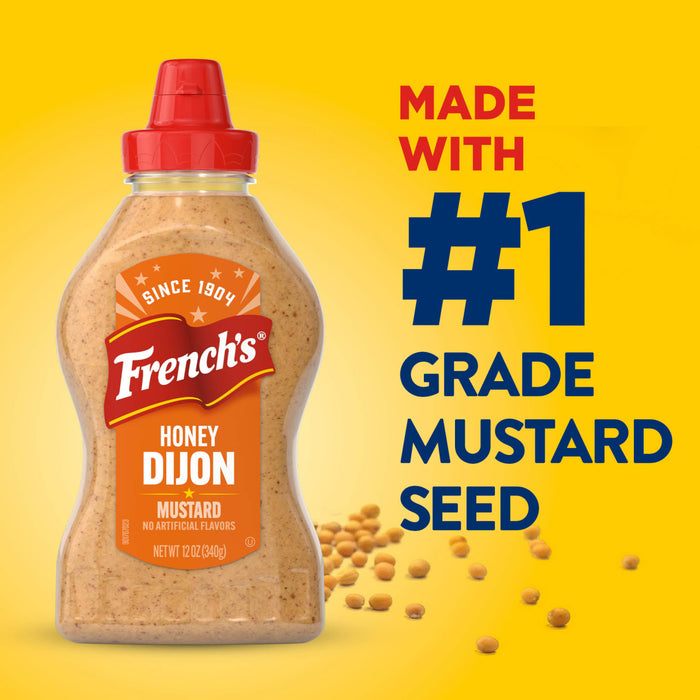 A bottle of Frenchs Brown Honey Dijon Mustard 12 Oz is displayed against a bright yellow background featuring the text Made With Number 1 Grade Mustard Seed and scattered whole seeds.