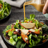 A fresh autumn salad featuring crisp greens, apple slices, pecans, and dried cranberries is drizzled with a savory dressing made from Frenchs Brown Honey Dijon Mustard 12 Oz.
