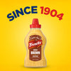 A bottle of French's Spicy Brown Mustard is centered on a yellow background with the words Since 1904, representing the quality found in products like Frenchs Dill Pickle Sandwich Spread Regular Inverted Squeeze Bottle Rp 12 Oz.