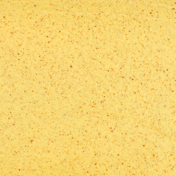 A close-up, textural shot of Frenchs Brown Spicy Brown Mustard 12 Oz shows its creamy yellow base and specks of brown spices.