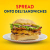 A serving suggestion shows a delicious deli sandwich with grilled chicken and bacon, featuring Frenchs Brown Spicy Brown Mustard 12 Oz spread on the bun.