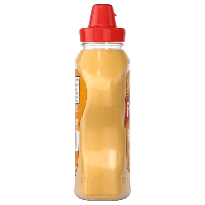 A side profile of a clear squeeze bottle of Frenchs Brown Honey Mustard 12 Oz, showing the texture of the mustard and the red flip-top cap.
