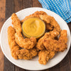 A plate of crispy chicken tenders is served with a bowl of Frenchs Brown Honey Mustard 12 Oz for dipping.