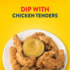 A white plate of crispy chicken tenders is arranged around a small bowl of Frenchs Brown Honey Mustard 12 Oz, ready for dipping.